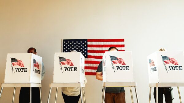 US election day, Diverse people at voting booth at US election station with American flag in background. Diverse people in line to vote at US election day. Vote for American democracy