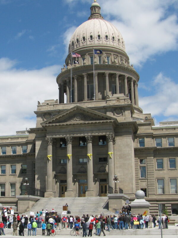 View of capitol building from afar with people standing near the steps