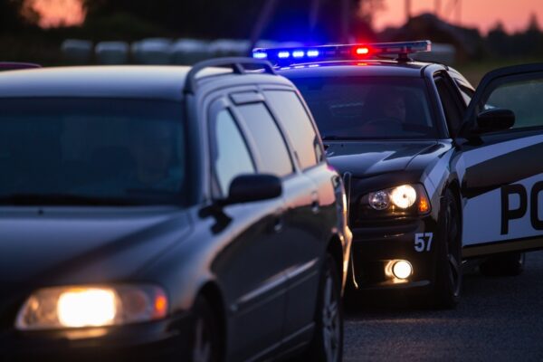 A police officer opens their door after pulling someone over