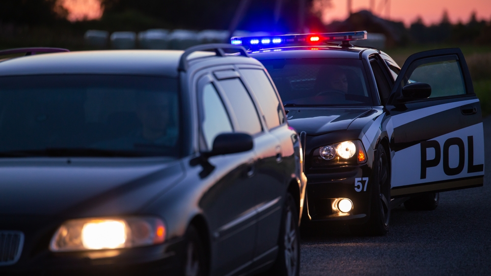 A police officer opens their door after pulling someone over