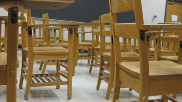 a bunch of desks in a classroom from a low vantage point