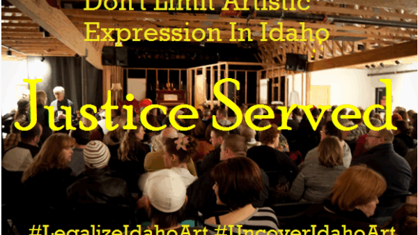 a venue with people sitting and waiting for the show to start from the back of the room, with words "Don't limit Artistic Expression in Idaho" "Justice Served" "#legalizeidahoart" and "#uncoveridahoart"