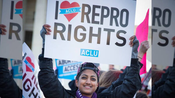 Person holding protest sign that says I (heart) REPRO RIGHTS and ACLU logo