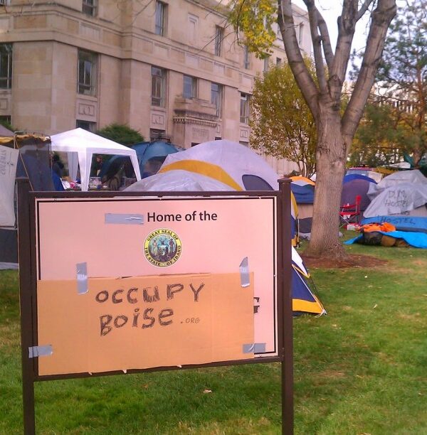 Occupy Boise tents and signs on the lawn of the old Ada County Courthouse, with a cardboard sign in front reading "Occupy Boise"
