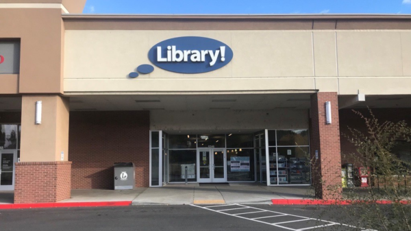 A picture of the Hillcrest Library in Boise. A light brown building with a blue circular sign that says "Library!"
