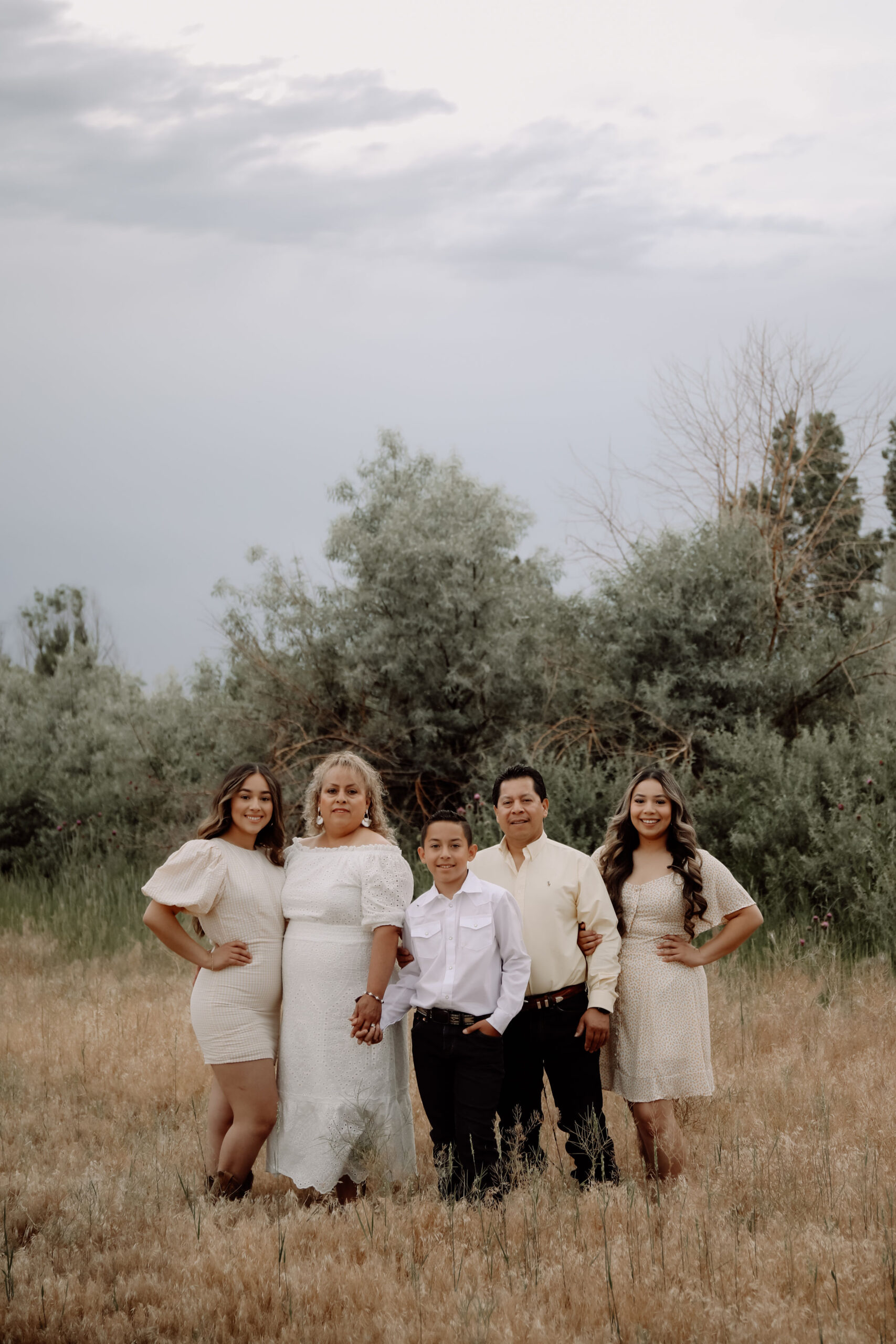 A photo of Natalie and her family, outside with trees in the background.