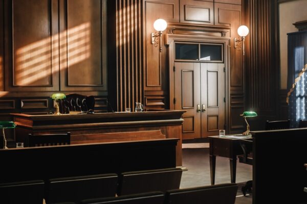 Image of a generic, empty courtroom with wood tones.