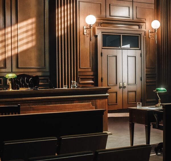 Image of a generic, empty courtroom with wood tones.
