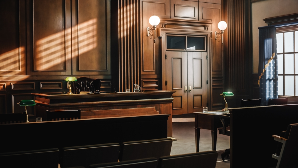 Image of a generic, empty courtroom with wood tones.