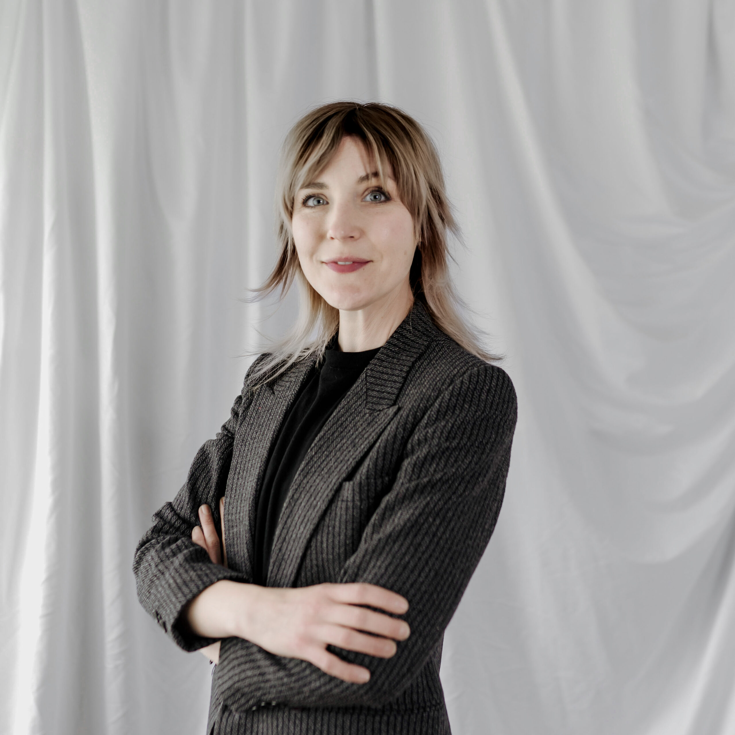 Photo of Amy Dundon, who is standing with arms crossed and smiling.