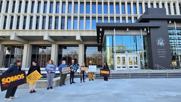 A group of eight advocates hold signs in support of immigrants standing in front of the federal court building in boise, idaho.