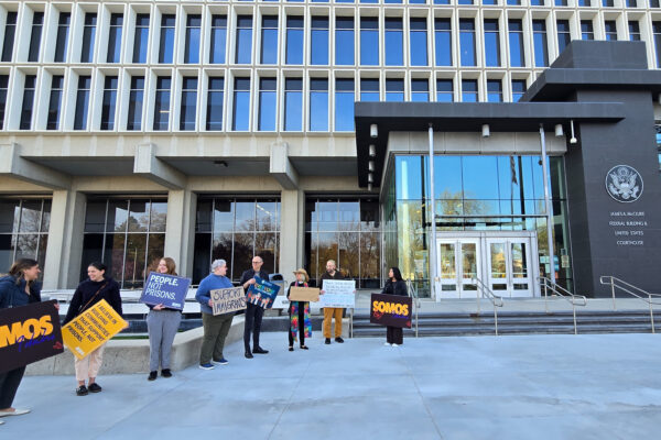 A group of eight advocates hold signs in support of immigrants standing in front of the federal court building in boise, idaho.