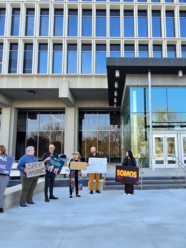 A group of eight advocates hold signs in support of immigrants standing in front of the federal court building in boise, idaho.