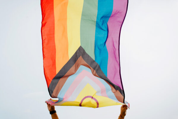 Person waving an LGBTQ+ flag