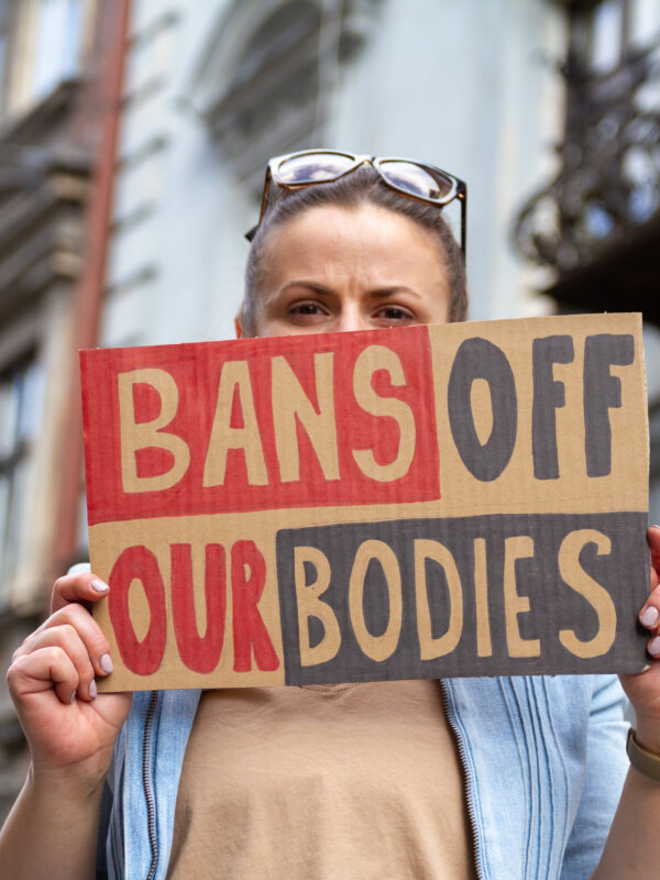 Woman holds a "bans off our bodies" sign