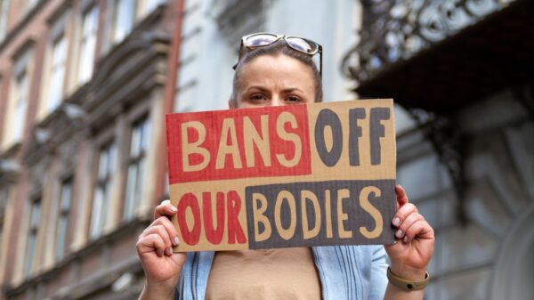 Woman holds a "bans off our bodies" sign