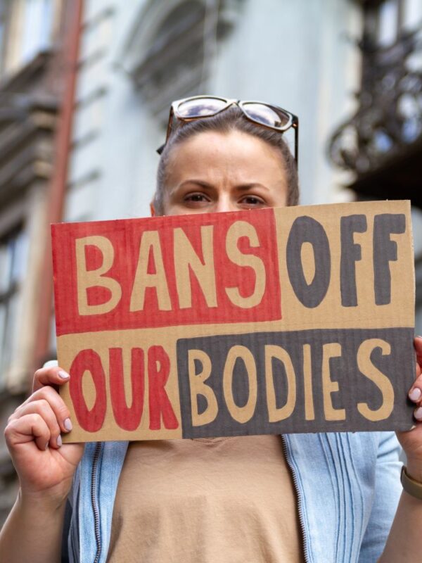 Woman holds a "bans off our bodies" sign