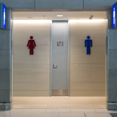 A public bathroom entrance with a men's and women's restrooms sign.