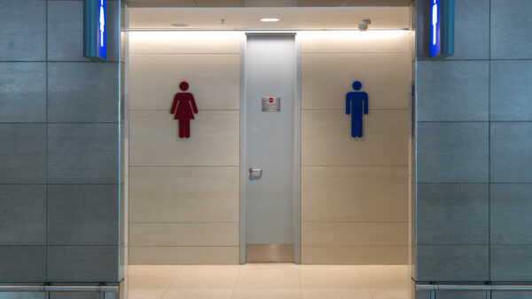 Front view of public restroom or toilet with man and women signs on marble wall. Way to clean restoom man and women toilet sign.