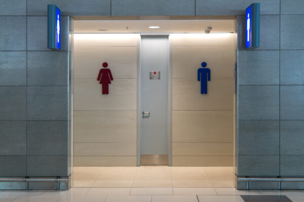 A public bathroom entrance with a men's and women's restrooms sign.