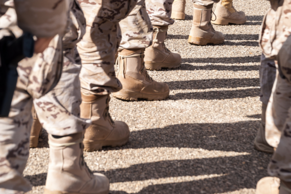 Ground view of National Guard troops in uniform, with only boots and camouflage pants showing