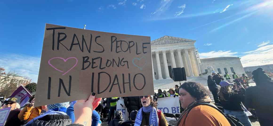 A person holds a sign saying "trans people belong in Idaho" in front of the U.S. Supreme Court building