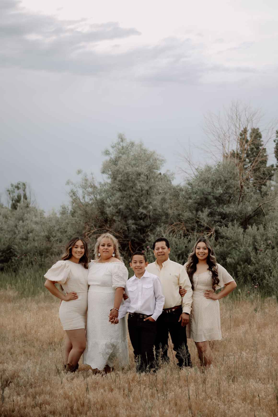 A photo of Natalie and her family, outside with trees in the background. 