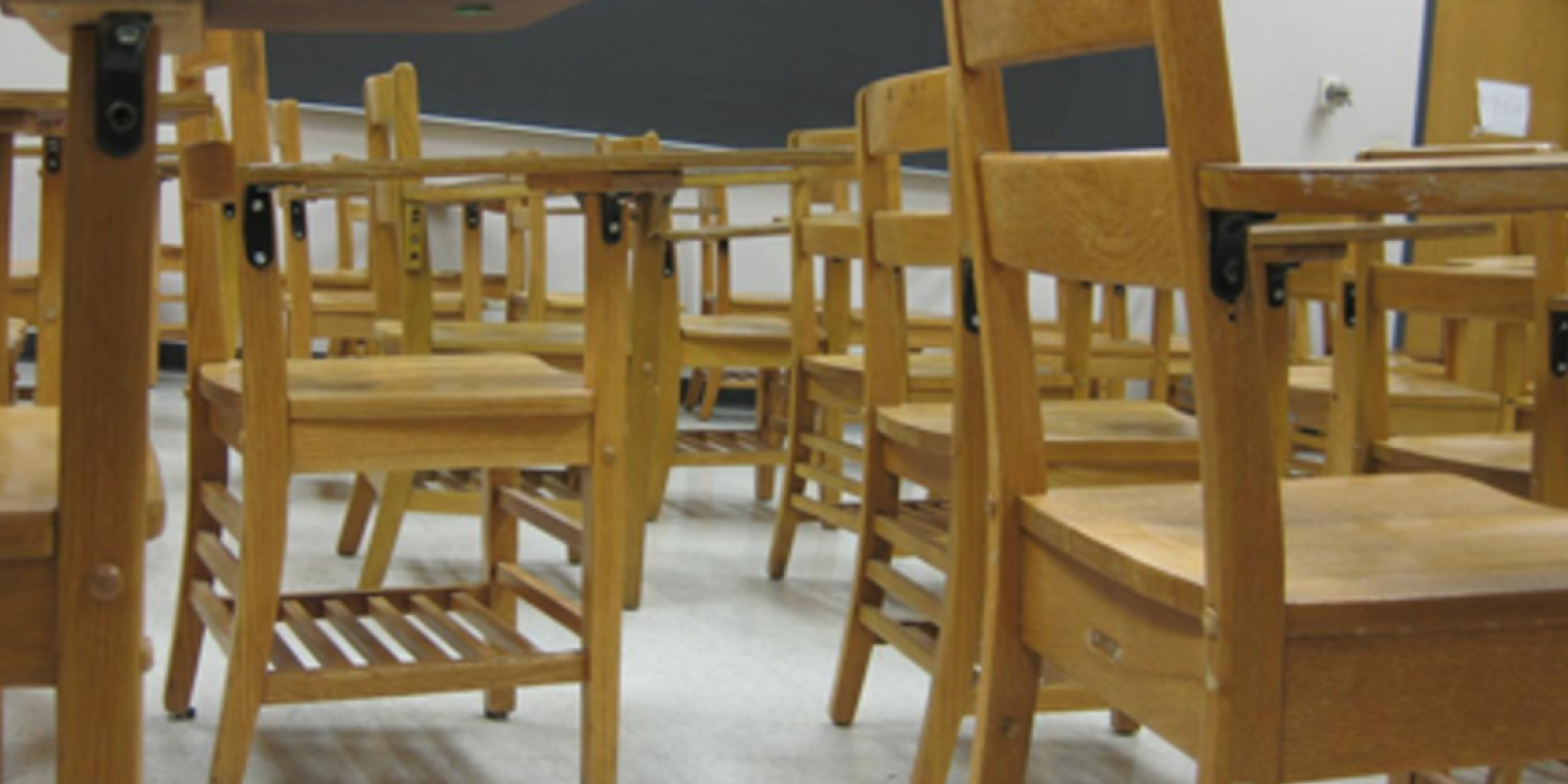 a bunch of desks in a classroom from a low vantage point