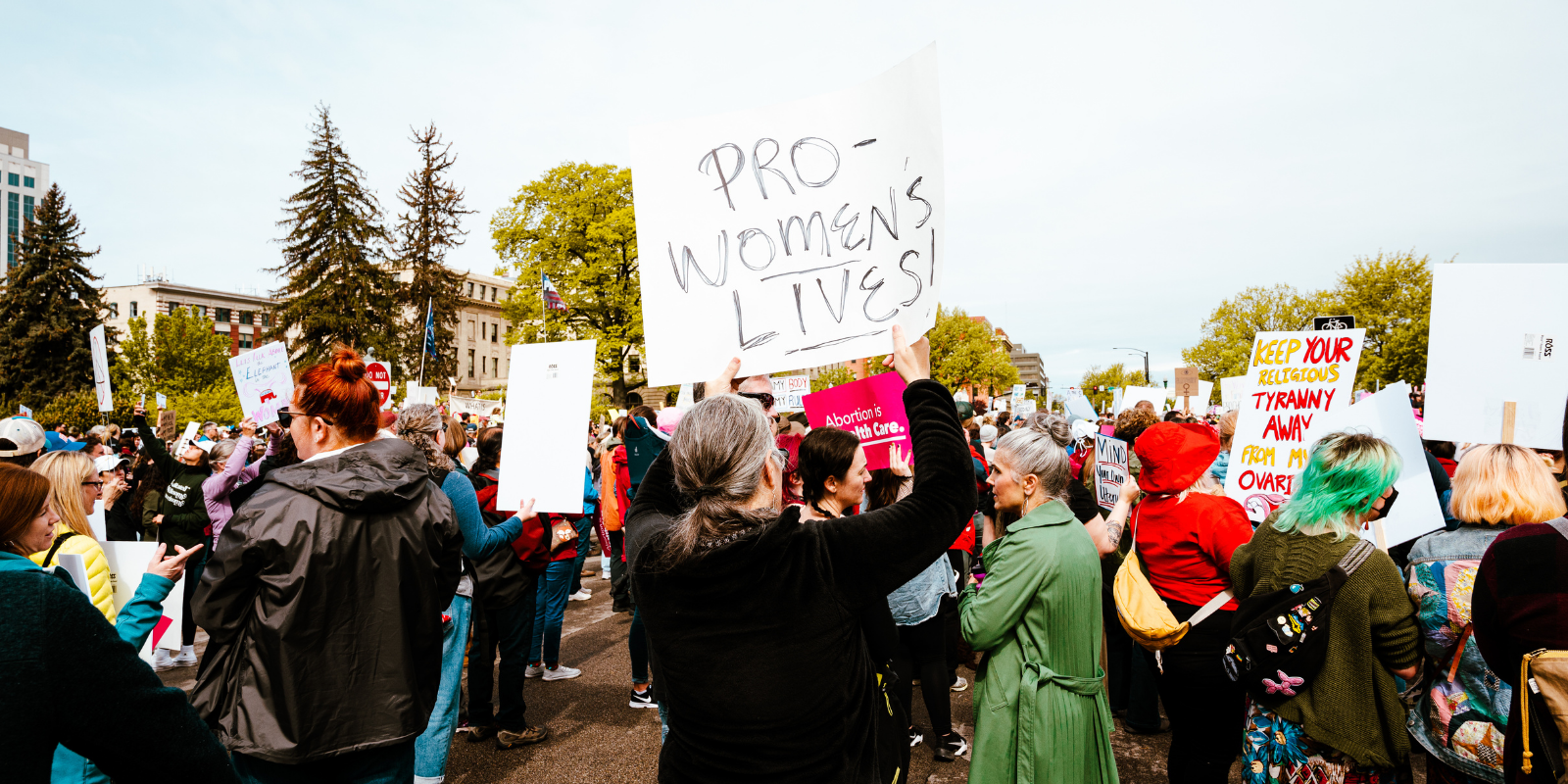 A woman at a protest holds a sign that says "pro women's lives"