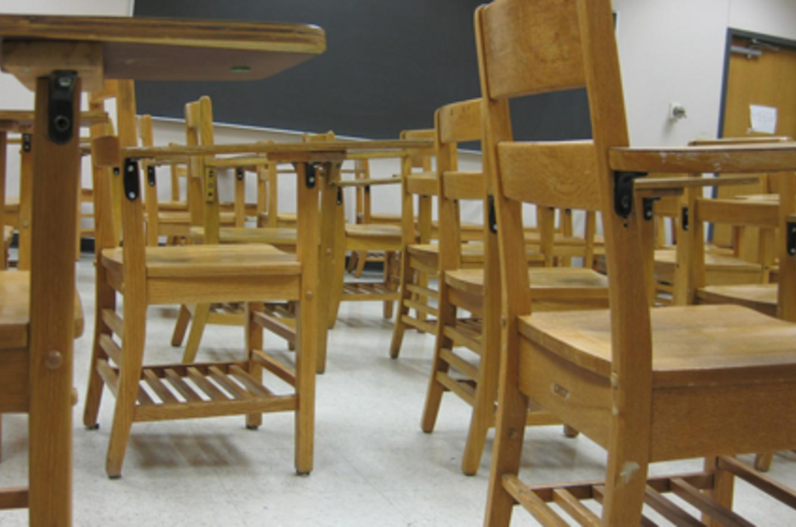 a bunch of desks in a classroom from a low vantage point