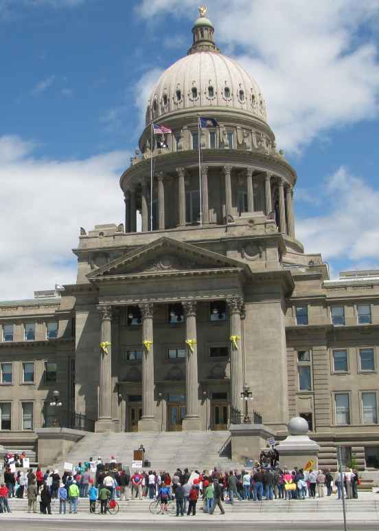 View of capitol building from afar with people standing near the steps