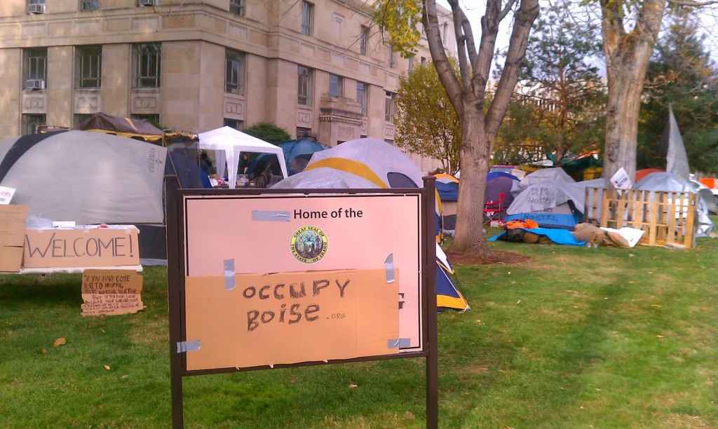 Occupy Boise tents and signs on the lawn of the old Ada County Courthouse, with a cardboard sign in front reading &quot;Occupy Boise&quot;