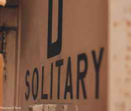 the word "solitary" on a wall