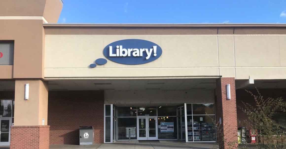 A picture of the Hillcrest Library in Boise. A light brown building with a blue circular sign that says "Library!"