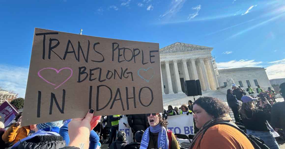 A person holds a sign saying "trans people belong in Idaho" in front of the U.S. Supreme Court building