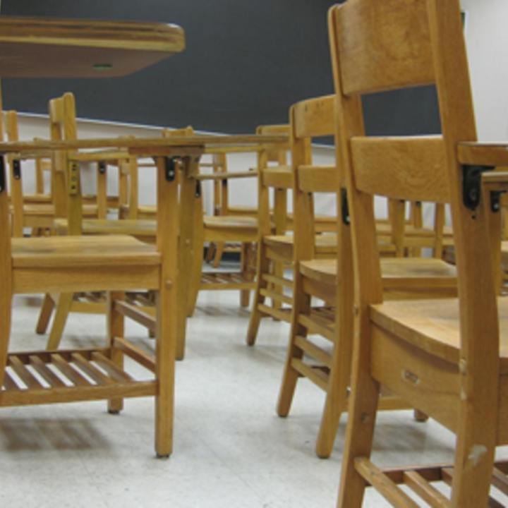 a bunch of desks in a classroom from a low vantage point