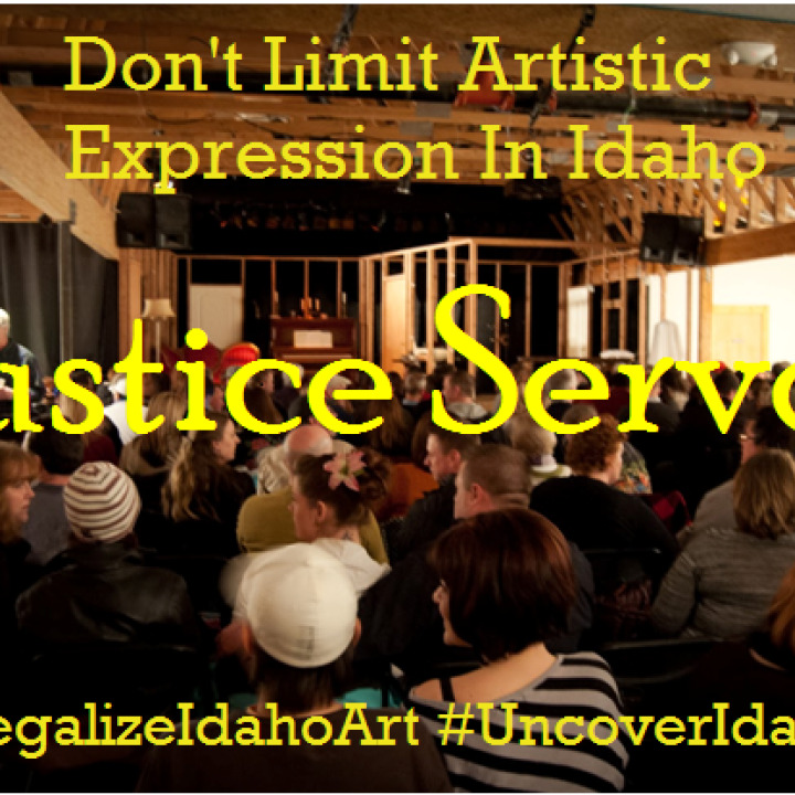 a venue with people sitting and waiting for the show to start from the back of the room, with words "Don't limit Artistic Expression in Idaho" "Justice Served" "#legalizeidahoart" and "#uncoveridahoart"